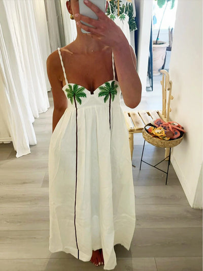 Photo miroir d’une robe blanche d’été avec motifs palmiers prise en intérieur.

