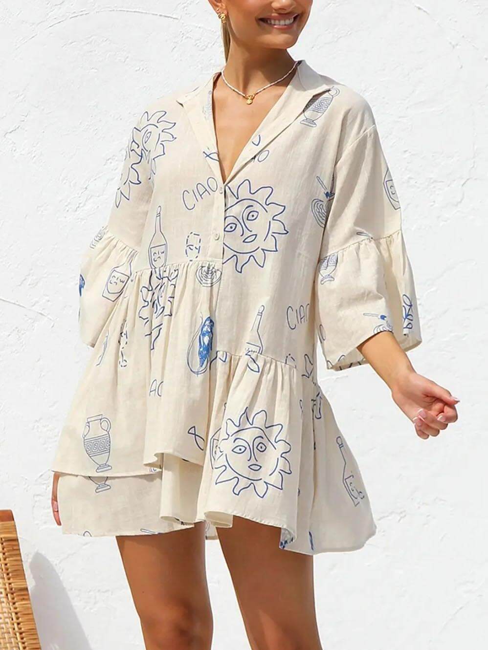 Robe tunique ample beige avec illustrations bleues, coupe fluide et col en V, vue de face.