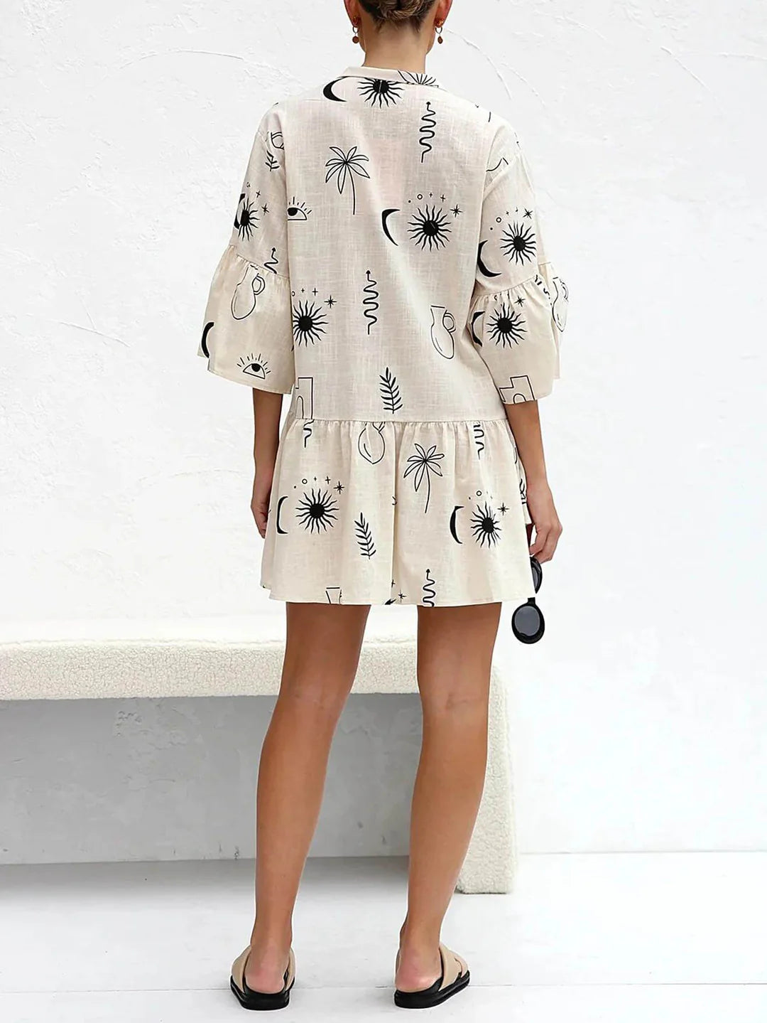 Robe courte beige avec illustrations noires minimalistes, vue de dos.