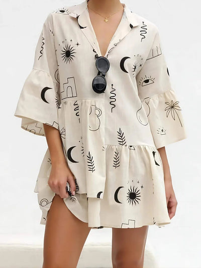 Robe ample beige avec motifs noirs graphiques, manches larges et col décolleté.