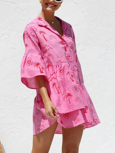 Robe courte rose à motifs tropicaux rouges, manches amples et col en V, vue de face.